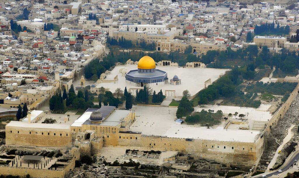 An overhead view of the Temple Mount complex in Jerusalem, showing the golden Dome of the Rock, stone plazas, and surrounding historic buildings.